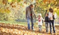man and woman with kids in fallen leaves