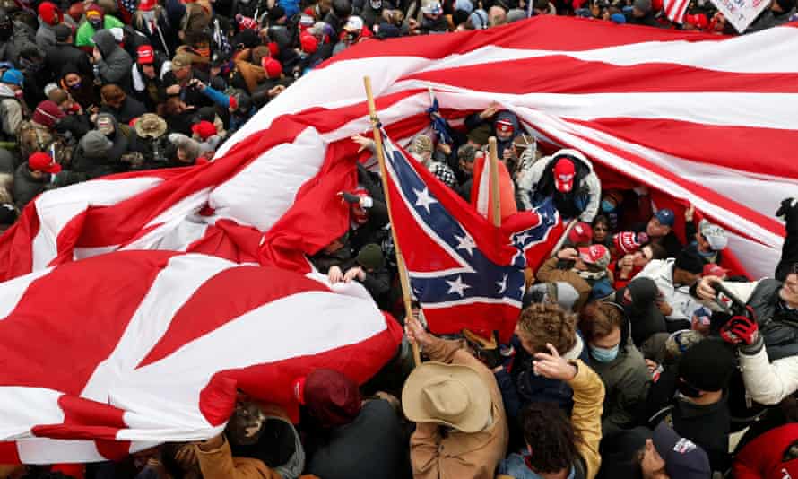 Protesters wave American and Confederate flags during clashes with Capitol police at a rally to contest the certification of the 2020 US presidential election results by the US Congress, at the Capitol Building in Washington, 6 January 2021.