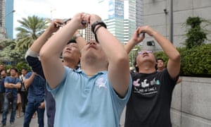 People using their mobile phones take photos of French urban free-climber Alain Robert in Manila, philippines