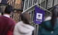People standing in front of an NYU campus flag.