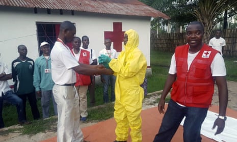 A member of a Red Cross team puts on protective clothing at a medical centre in Mbandaka, DRC