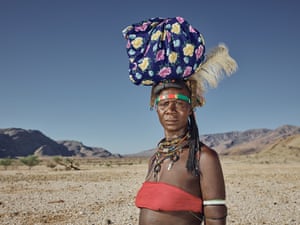 Mbawiramo Katanga, 37, looks at the camera in a parched landscape with a bag on her head