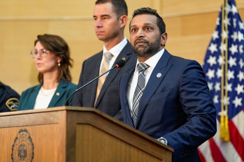 a man in a suit stands behind a microphone