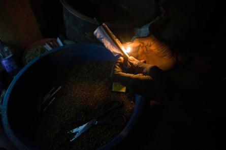 In a kiosk in Kisenyi a child seals a homemade marijuana cigarette.