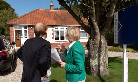 House buyers viewing a house with a for sale sign.