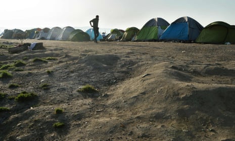 A refugee man walks in the makeshift camp at the Greek-Macedonian border