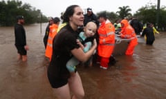A woman carries a baby as flooding occurs in Lismore on February 28th. A severe weather warning is in place as wild weather and dangerous flooding continues to severely impact large swathes of NSW and Queensland.