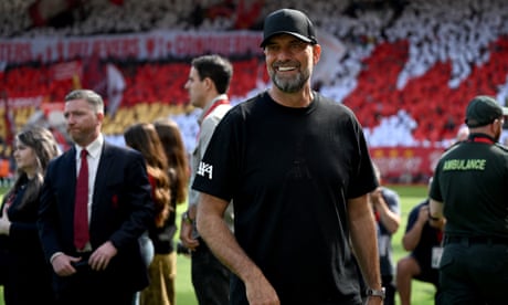 Jürgen Klopp stands in front of tributes in the stands at Anfield.