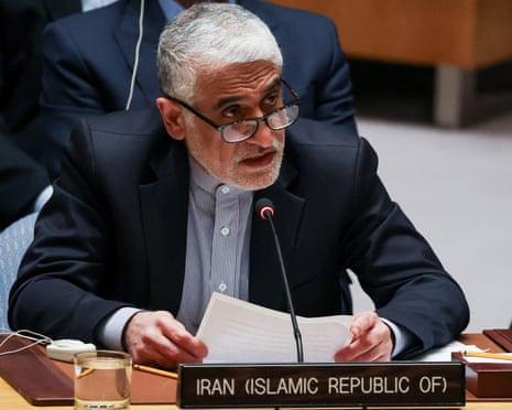 Amir-Saeid Iravani speaking into a microphone and reading from papers