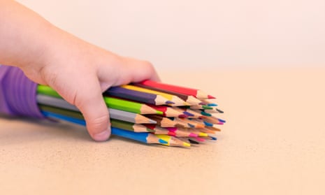 A child holding some coloured pencils