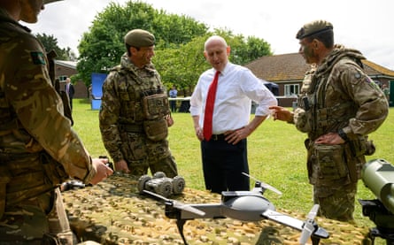 John Healey looking at a drone with military personnel.