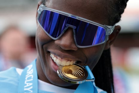 Manchester City's Khadija Shaw celebrates with her medal after winning the Women's Super League – bites her medal.