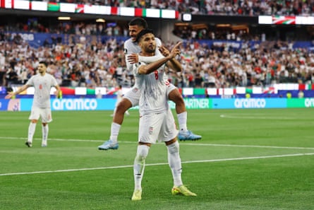 Iran’s Mohammad Mohebbi celebrates scoring their second goal with Mehdi Ghayedi.