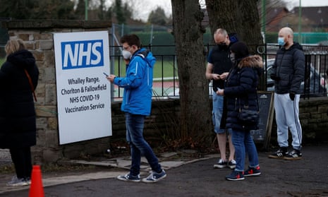 People queue for booster jabs outside a coronavirus  vaccination centre in Manchester