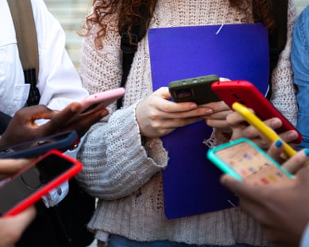 A group of young people all looking at their phones