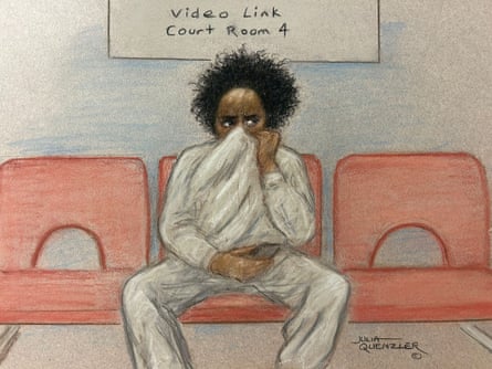 An artist’s sketch of Axel Rudakubana, who has curly black hair and is wearing a grey tracksuit, sitting on the middle of three red chairs, pulling his top up which covers the lower part of his face.