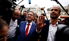 Manuel Bompard and Jean-Luc Melenchon are surrounded by journalists as they arrive at the National Assembly in Paris, 9 July 2024. Bompard has one hand raised and appears to be addressing someone. He is in his late 30s and has receding dark hair; he wears an open-necked white shirt and black jacket; Mélenchon is in his early 70s and has short grey hair and glasses; he wears a royal blue suit, white shirt and red tie.
