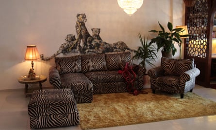 A pack of cheetahs crouch over a zebra-print sofa, where entrails snake out of a cushion
