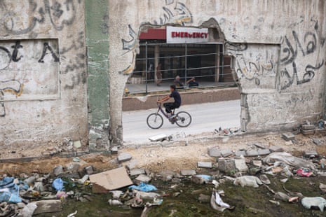 A Palestinian boy cycles past the damaged Nasser hospital in Khan Younis in the southern Gaza Strip on Thursday.