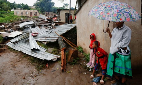 People stand near the remains of a building at KwaNdengezi station, near Durban, South Africa