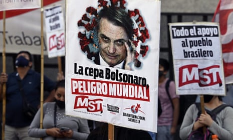 People hold banners depicting Brazil’s President Jair Bolsonaro reading ‘The Bolsonaro strain, world danger’ during a protest of members of leftist parties outside the Brazilian embassy in Buenos Aires on Wednesday.