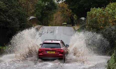 A car drives along a flooded road in Romsey, southern England.