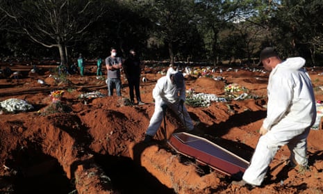 Gravediggers wearing protective suits bury the coffin of Izolina de Sousa, 85, who died from the coronavirus disease in Sao Paulo, Brazil