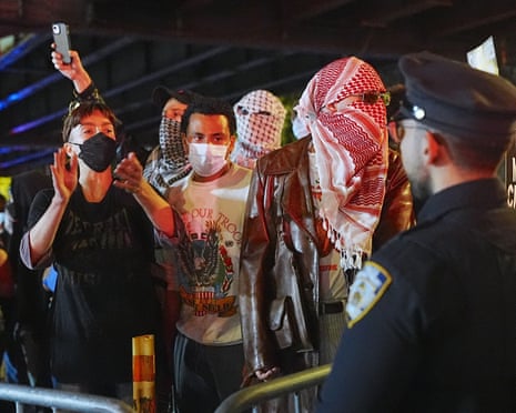 three people in masks stand in a line