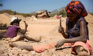 Una donna e un bambino rompono rocce estratte da una miniera di cobalto a Lubumbashi, Repubblica Democratica del Congo