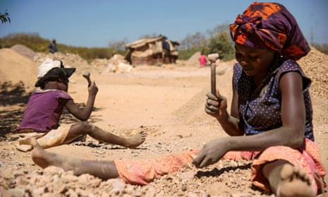A woman and child break rocks extracted from a cobalt mine in Lubumbashi, DRC
