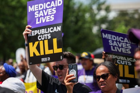 people hold signs that read 'Medicaid saves lives Republican cuts kill'