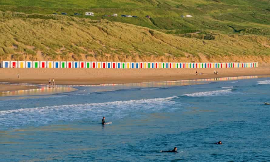 Saunton Sands beach with sand dunes and a line of colorful and painted beach huts on Devon Beach