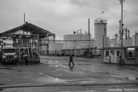 An industrial worker walks toward a fueling station outside