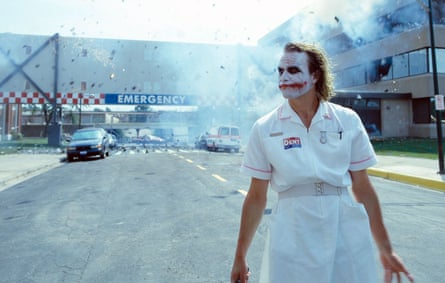 Wearing a nurses uniform and the Joker’s makeup, he walks away from a hospital that has just exploded