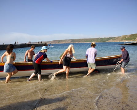 People carry a large canoe into the water