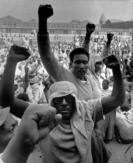 Inmates at Attica state prison in New York raise their fists in solidarity during a negotiation session with the state prisons commissioner, Russell Oswald, on 10 September 1971.