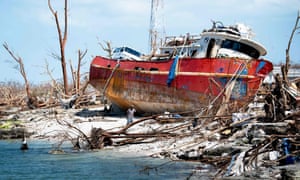 People recover items from a beached boat in Marsh Harbour on 5 September.