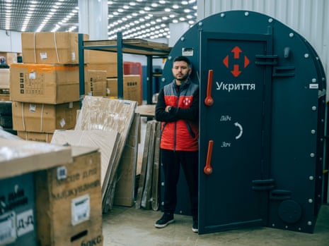 Nova Poshta branch manager Yaroslav Dobronos stands by the ‘capsule’ bomb shelter in the post office.