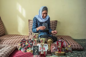 Nazira sits in her home in Afghanistan in March last year with some of the sports trophies and medals she has won.