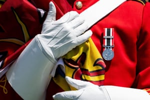A Royal Canadian Mounted Police guard holds a flag to his chest