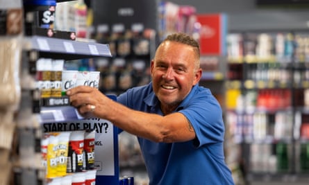 Andy Barnard smiles towards the camera as he stacks shelves in a Lincoln Co-op
