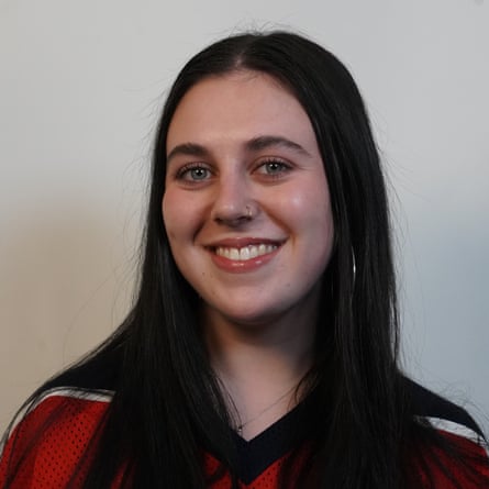 A young woman in a red shirt smiles