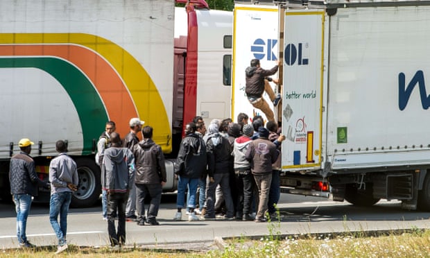 People climbing into the back of a lorry in Calais, northern France