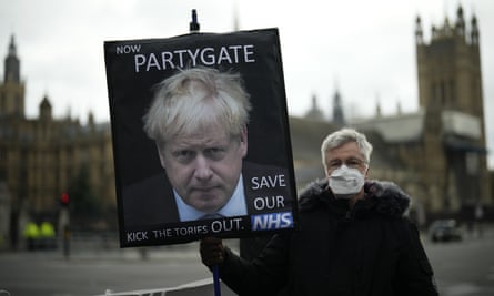 A protester holds a placard protesting about ‘partygate' in London last month