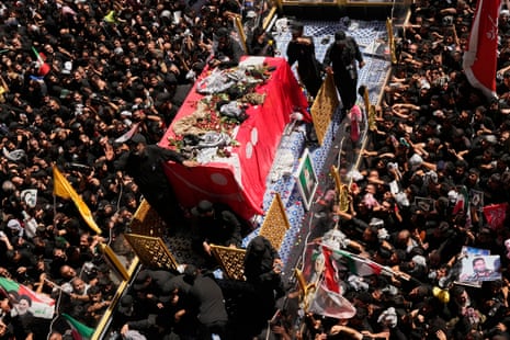 Hundreds of mourners surround a vehicle carrying the coffin of Iranian supreme leader Ayatollah Ali Khamenei during a funeral procession.