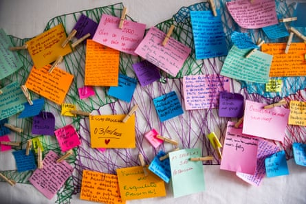 A wall of coloured cards with handwriting on them connected by cat’s cradle of string