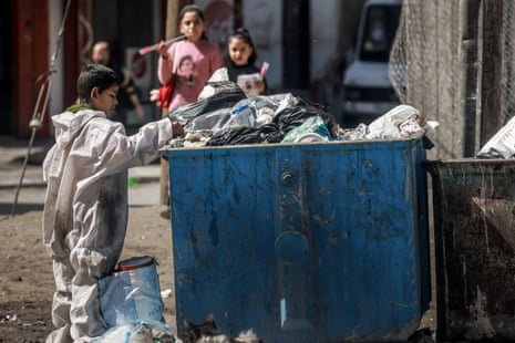 A Palestinian boy inspects a garbage container as he looks for cartons to make a fire in the Rafah refugee camp in the southern Gaza Strip.