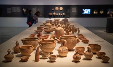 display on a long table of antiquities including pottery jugs, bowls and containers