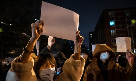 Protesters hold up pieces of paper at a demonstration in Beijing on Sunday.
