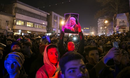 A mourner holds up a picture of Ali Akbar Hashemi Rafsanjani